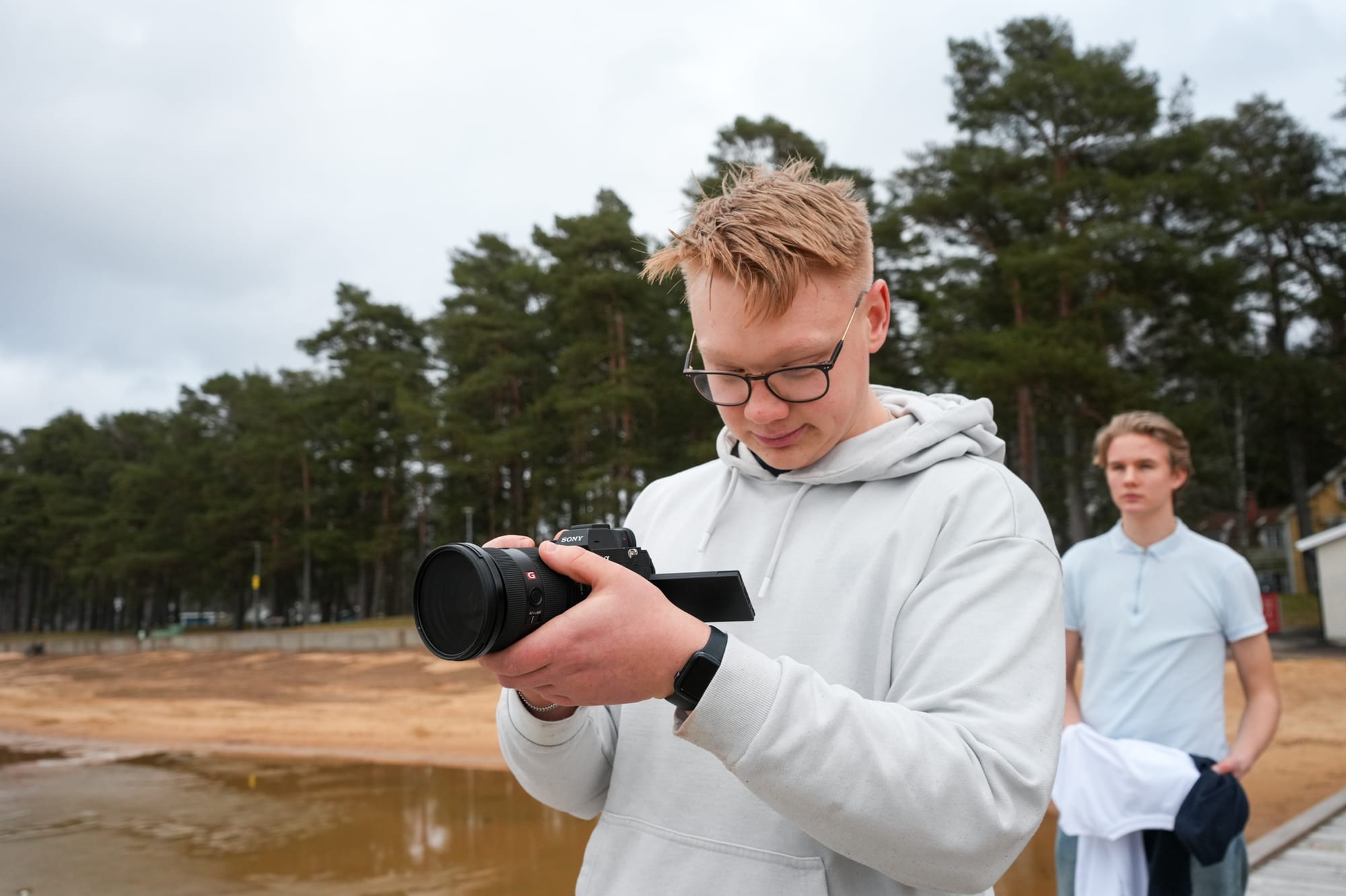 Albin Kindevåg tittar ner på sin kamera under en fotografering i Motala