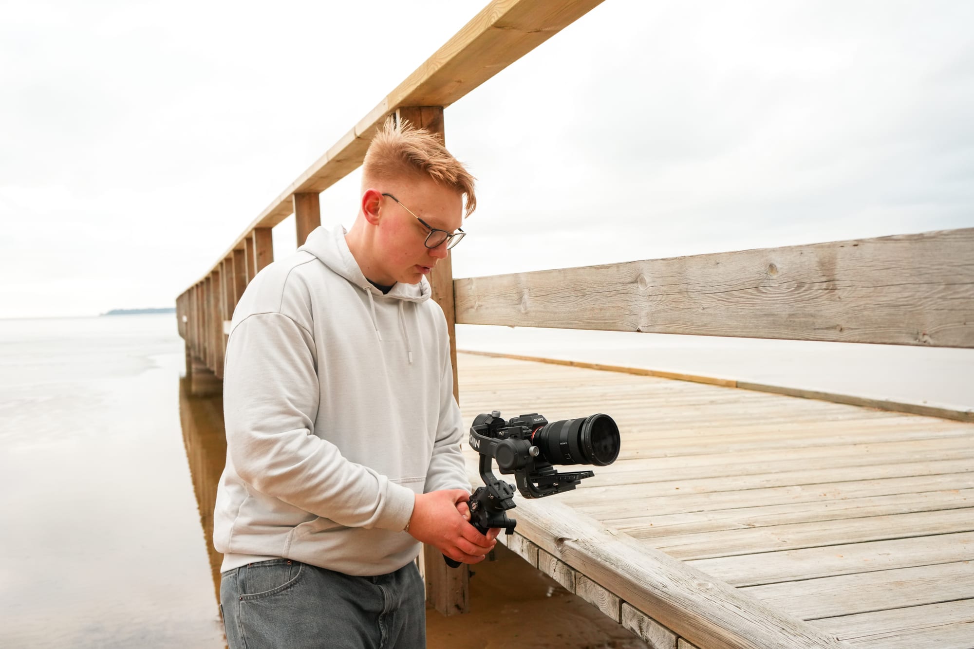 Albin Kindevåg, grundare av Teksmedia, filmar med gimbal och kamera på en brygga i Motala